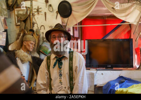 Der Landmann innerhalb der mittelalterlichen Mauern von Sighisoara erzählt Geschichten über die Vergangenheit. Der Fernseher im Hintergrund ist eine interessante Opposition. Stockfoto