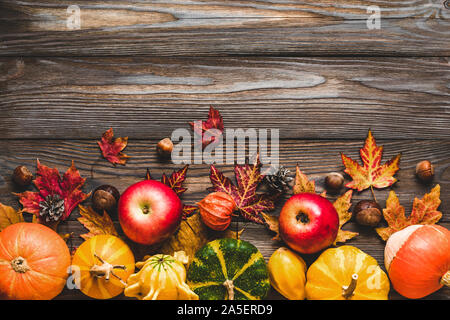 Happy Thanksgiving Konzept. Herbst Komposition mit Kürbissen, Laub, trockene Blumen, Beeren und Nüsse auf rustikalen Holztisch. Flach, Ansicht von oben Stockfoto