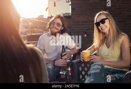 Freunde haben kostenlos und einfach sprechen, während Sie sich auf einen Sommerabend Terrasse Stockfoto