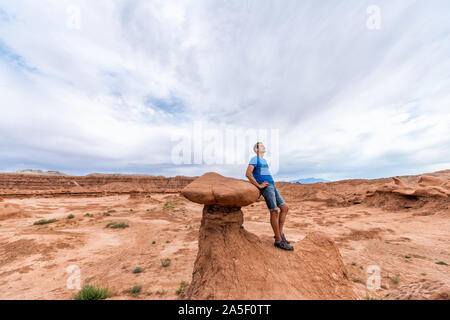 Mann Wanderer auf hoodoo Sandstein Felsformationen Wüstenlandschaft im Goblin Valley State Park in Utah auf der Spur Stockfoto