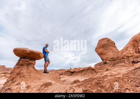 Mann Wanderer auf einzigartige hoodoo Sandstein Felsformationen Wüstenlandschaft im Goblin Valley State Park in Utah auf der Spur Stockfoto