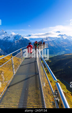 Grindelwald, Schweiz - Oktober 10, 2019: Leute die Bilder auf Sky Cliff Walk Metal Bridge auf den ersten Gipfel der Schweizer Alpen Berge, Schnee, Gipfel Pano Stockfoto