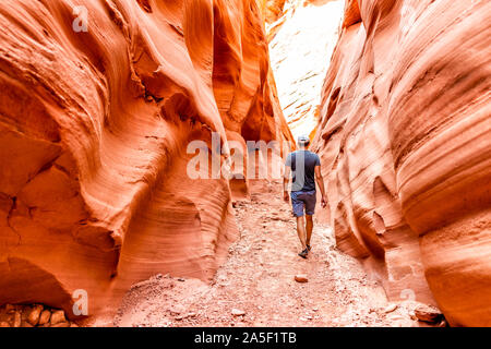 Mann Wanderer zu Fuß durch rote Welle Form Formationen auf Antelope Slot Canyon in Arizona am Wanderweg Wanderweg von Lake Powell. Stockfoto