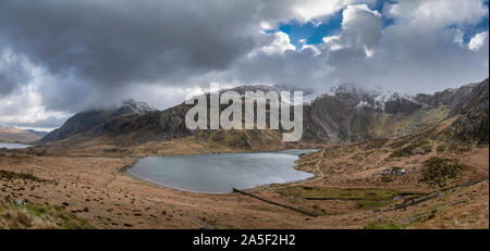 Atemberaubende dramatische Winterlandschaft Bild von Llyn Glyders Idwal und schneebedeckten Bergkette in Snowdonia Stockfoto