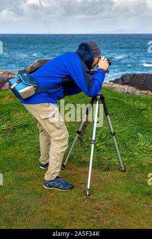 Junger Mann fotografieren Landschaft mit Kamera und Stativ Stockfoto