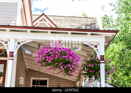 Skiort Haus mit alten schönen Architektur und Veranda von generischen typische Gebäude Exterieur Nahaufnahme von rosa Blume Dekorationen in Tellu Stockfoto
