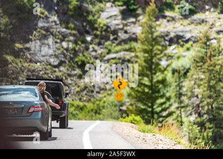 Ouray, USA - 14. August 2019: Frau mit Kopf außerhalb Auto stehend durch das Fenster an der malerischen Straße in Colorado Sommer auf Million Dollar Highway 550 Stockfoto