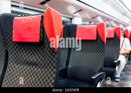 Leeres rotes bequemen Stühlen sitze Reihe Nahaufnahme in Gang, in der u-bahn innen innen mit Person im Hintergrund und Moderne bequeme Sitzgelegenheiten sitzen Stockfoto