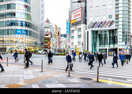 Tokyo, Japan - 28. März 2019: Shinjuku Zebrastreifen mit Verkehr von Masse viele Menschen überqueren die Straße im morgendlichen Berufsverkehr pendeln auf der Straße in der Nähe von Pachinko Stockfoto