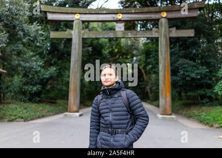 Meiji Schrein hölzerne Tor Eingang mit touristischen Mann in Tokio während kalter Frühling auf der Bahn Straße Stockfoto