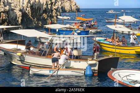 Insel Capri, Italien - AUGUST 2019: Besucher in kleinen Booten warten auf die "Grotta Azzurra" oder "Blaue Grotte" Grotte auf der Insel Capri besuchen Stockfoto