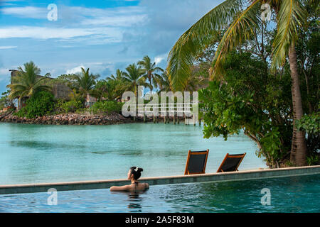 Schöne asiatische Frau im Infinity-pool an Likuliku Resort, Malolo Island Mamanucas Inselgruppe Fidschi Stockfoto