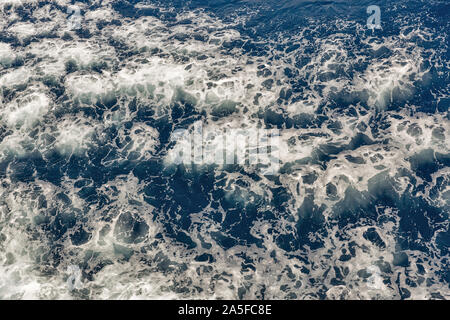 Brodelnde Oberfläche der Tiefsee mit weißer Schaum Hintergrund direkt von oben Stockfoto