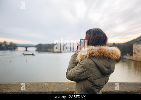 Die Frau ist, die Bilder auf der Karlsbrücke in Prag. Junge schöne Mädchen touristische steht auf der Karlsbrücke in Prag in der Tschechischen Republik Stockfoto