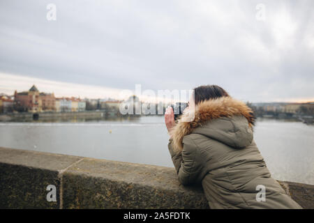 Die Frau ist, die Bilder auf der Karlsbrücke in Prag. Junge schöne Mädchen touristische steht auf der Karlsbrücke in Prag in der Tschechischen Republik Stockfoto