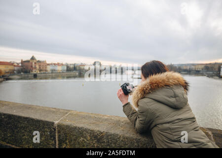 Die Frau ist, die Bilder auf der Karlsbrücke in Prag. Junge schöne Mädchen touristische steht auf der Karlsbrücke in Prag in der Tschechischen Republik Stockfoto