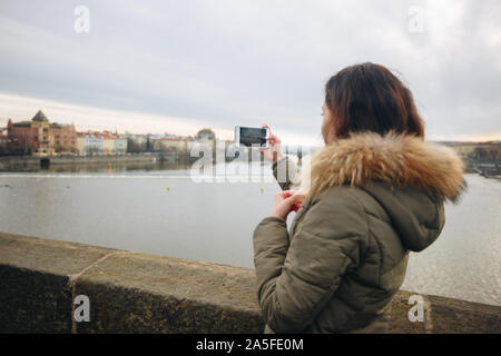 Die Frau ist, die Bilder auf der Karlsbrücke in Prag. Junge schöne Mädchen touristische steht auf der Karlsbrücke in Prag in der Tschechischen Republik Stockfoto