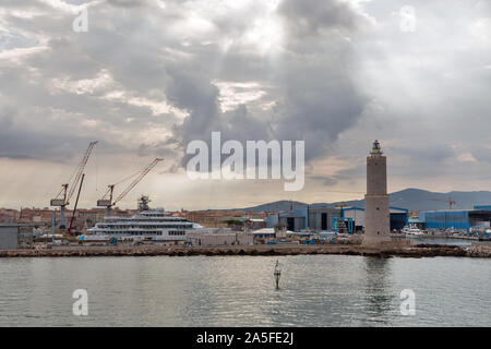 Stadtbild mit Leuchtturm und Livorno Hafen, in dramatischen Himmel Dawn. Der Hafen von Livorno ist eine der größten Seehäfen sowohl in Italien als auch das Mediterranea Stockfoto