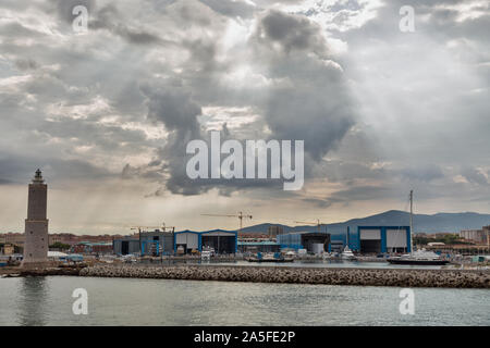 Stadtbild mit Leuchtturm und Livorno Hafen, in dramatischen Himmel Dawn. Der Hafen von Livorno ist eine der größten Seehäfen sowohl in Italien als auch das Mediterranea Stockfoto