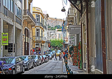 Athen, Attika, Griechenland - 17. Oktober 2018: Touristen wandern und die Einkaufsmöglichkeiten an ein Motorrad und Auto gesäumten Straße in Athen mit Akropolis hil Stockfoto