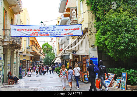 Athen, Attika, Griechenland - 17. Oktober 2018: Touristen wandern und Shopping in einem Flohmarkt entlang einer Athen, Griechenland Stadt Straße mit Apartments und hom Stockfoto