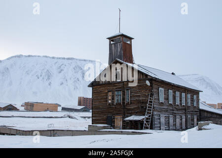 Pyramiden, Norwegen - August 2017: Alte verlassene Gebäude in Svalbard. Berge mit Schnee im Hintergrund. Stockfoto