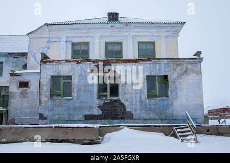 Pyramiden, Norwegen - August 2017: Alte verlassene Gebäude in Svalbard. Berge mit Schnee im Hintergrund. Stockfoto