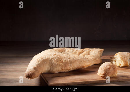 Georgische Brot lavash mit zerrissenen Stücke auf der hölzernen Hintergrund. Köstliche traditionelle hausgemachte Brot in Georgien. Nahaufnahme, horizontal mit kopieren. Stockfoto