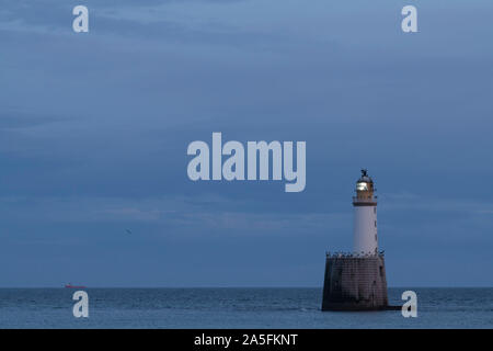 Rattray Head Lighthouse blinkt in der Dämmerung wie ein Boot übergibt den Horizont aus der nordöstlichen Küste von Schottland Stockfoto