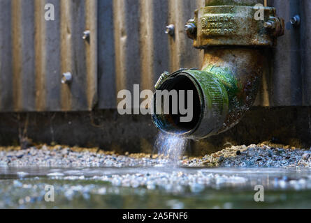 Regenwasser Abflußrohr. Regenwasser aus einem Abflußrohr auf der Seite eines Gebäudes. Stockfoto