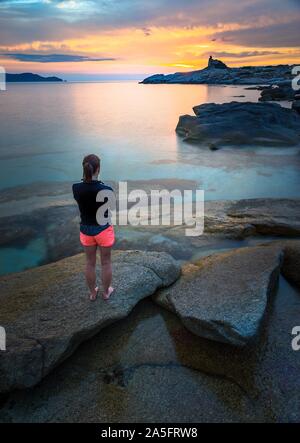Frau am Strand mit Blick auf den Sonnenuntergang, Korsika, Frankreich Stockfoto