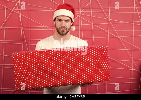 Am Morgen vor Weihnachten. lieferung Weihnachtsgeschenke. Mann den Urlaub genießen. Mann in santa hut halten Weihnachtsgeschenk. Frohe Weihnachten und schöne Feiertage. Helle Erinnerungen. Stockfoto