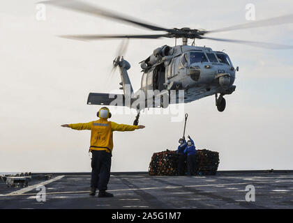 SOUTH CHINA SEA (Okt. 2010) 20, 2019) der Bootsmann Mate 2. Klasse John King leitet eine MH-60S Hubschrauber von der "Insel der Ritter" Hubschrauber Meer Combat Squadron (HSC) 25, Distanz 3, während eine vertikale Auffüllung-auf-See mit dem Dry Cargo und Munition ship USNS Carl Brashear (T-AKE 7) an Bord der Whidbey Island-Klasse dock Landung Schiff USS Germantown (LSD 42). Germantown, Teil der Kommandant, Amphibischen Squadron 11, ist mit dem indopazifischen Region bereitgestellt Interoperabilität mit Partnern zu verbessern und dienen als ready-Response Force für jede Art von Kontingenz. (U.S. Marine Foto von Masse Kommuniz Stockfoto