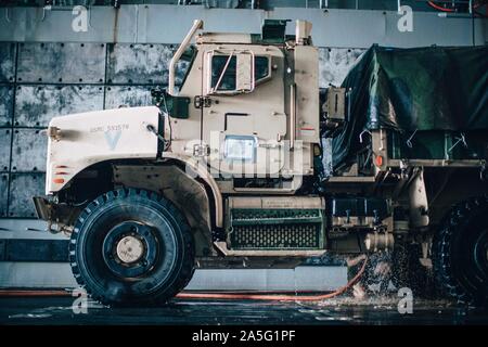 Ein US-Marine mit Alpha Batterie Bataillon Landung Team 3/5, 11 Marine Expeditionary Unit, reinigt die Unterseite eines 7-Tonnen-LKW in das Deck des San Antonio-Klasse amphibious Transport dock Schiff USS John S. Murtha LPD (26), nach Abschluss der Übung KAMANDAG 3 auf den Philippinen, Okt. 18, 2019. KAMANDAG Fortschritte militärische Modernisierung und Entwicklung von Fähigkeiten durch Experten Austausch. (U.S. Marine Corps Foto: Staff Sgt. Donald Holbert) Stockfoto