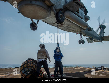 191017-N-SS 350-1042 ROTES MEER (Okt. 2010) 17, 2019) Segler sichere Ladung zu einem MH-60R Sea Hawk Hubschrauber, zugeordnet zu den "Großmeistern" der Hubschrauber Maritime Strike Squadron (HSM) 46, während eine vertikale Auffüllung Ausbildung an Bord der geführte Anti-raketen-Zerstörer USS Bainbridge (DDG96). Bainbridge ist in die USA 5 Flotte Bereich der Maßnahmen zur Unterstützung der Marine im Einsatz für die Stabilität und Sicherheit in der Region zu gewährleisten und verbindet das Mittelmeer und den Pazifischen Raum durch den Westlichen Indischen Ozean und drei strategischen Punkten ersticken. (U.S. Marine Foto von Mass Communication Specialist 3 Stockfoto