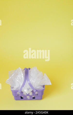 Polyäthylenbeutel im Warenkorb auf gelben Hintergrund. Stockfoto