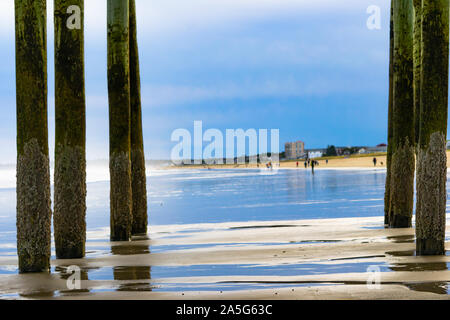 Old Orchard Beach, ME, Oktober 10, 2019: Ein vew durch Barnacle abgedeckt pier Masten an der Küste Stockfoto