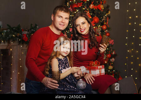 Freundliche Familie feiert Weihnachten. Wohnzimmer in hellen Weihnachtsbeleuchtung. Urlaub Dekorationen. Winter Weihnachten zusammen. Frohes neues Jahr. Stockfoto