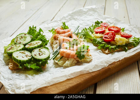 Scheiben von Waffel Brot mit verschiedenen Gemüse, Garnelen und Würzen. Stockfoto