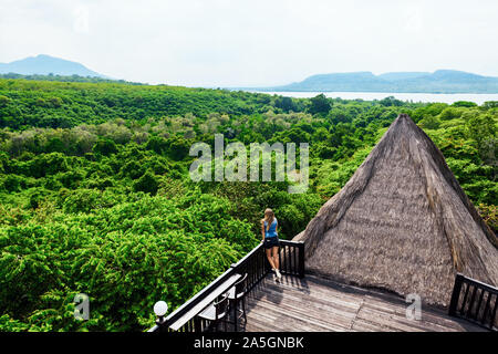 Glückliche Familie reisen, erkunden Sie den Regenwald in der Nähe von Menjangan Pemuteran. Junge Frau auf lounge Veranda mit tropischen Dschungel Aussicht entspannen. Walking Tour. Stockfoto