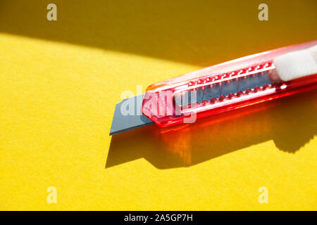 Ein sehr Scharfes Teppichmesser liegt in der Fensterbank mit im Sonnenlicht Stockfoto