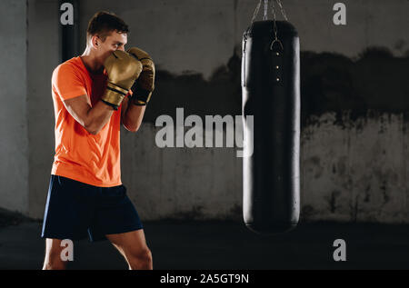 Junger Mann in Boxhandschuhen. Boxing Man bereit zu kämpfen. Boxen, Workout, Muskel, Stärke, Kraft, der Begriff der Krafttraining Stockfoto