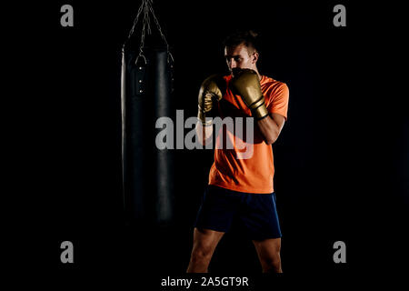 Junge Boxer dabei einige Training am Boxsack Fitnessraum. Kaukasische boxer Training mit Boxsack in der Turnhalle. Konzept für einen gesunden Lebensstil Stockfoto