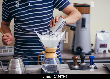 Sie gießen über Kaffee mit heißem Wasser aus dem Wasserkocher geschüttet wurde Stockfoto