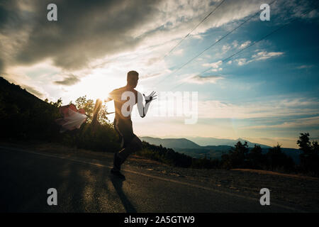 Verschwitzten Mann laufen über die ländliche Straße. Hispanic männlichen Athleten Training und trainieren hart für intensive Marathon Stockfoto