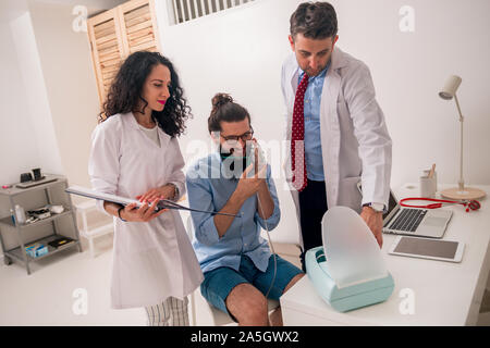 Patienten Hipster in einem Asthmaanfall im Doktorbüro Stockfoto