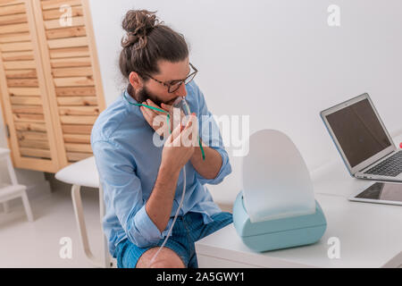 Patienten Hipster in einem Asthmaanfall im Doktorbüro Stockfoto