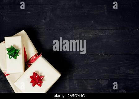 Oben Aufnahme einer schwarzen Holzfläche mit Geschenken auf Unten Stockfoto