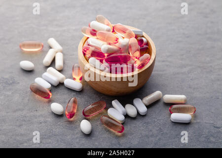 Sortiment verstreut pharmazeutische Medizin Vitamine, Pillen, Drogen in Houten auf grauem Hintergrund. Weiß Lebensmittel diätetische Ergänzung harte Schale Kappen Stockfoto