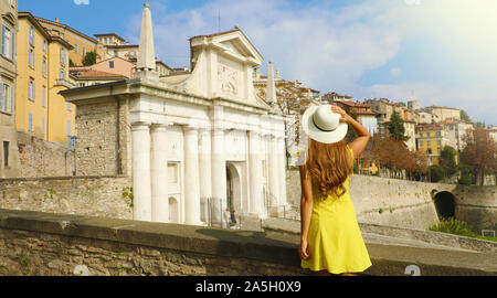 Schöne junge Frau mit Hut genießen Aussicht von Mauern von Porta San Giacomo Tor und der Oberen Stadt Bergamo, Italien. Stockfoto